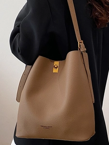 Vintage brown leather bucket bag for women with metal clasp and adjustable shoulder strap