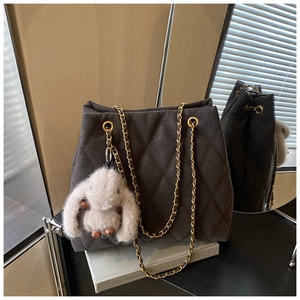 Detail van donkergrijze gewatteerde shopper met gouden ketting en schattig konijntje