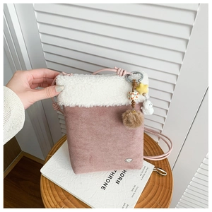 Detail of pink faux suede crossbody bag with plush white trim and cute star charms