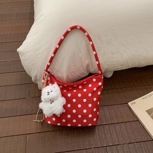 Détail du sac à bandoulière rouge à pois avec charmant porte-clés ours en peluche blanc