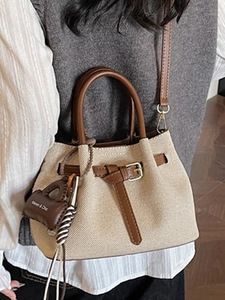 Retro canvas bucket bag with brown leather trim and crossbody strap on female model