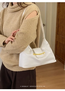 Détail du sac baguette vintage blanc avec texture souple et garniture métallique dorée