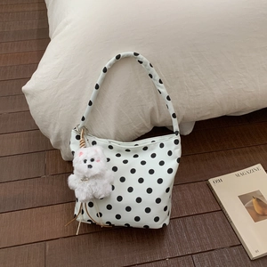 Détail du sac à bandoulière blanc à pois avec un charmant chien en peluche et étiquette métal