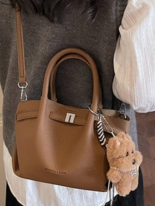 Sac seau en cuir marron avec pendentif ours porté en sac à bandoulière et à l'épaule