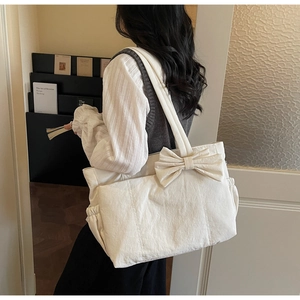 Detailed close-up of cream white canvas tote bag with a large decorative bow