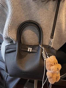 Sac seau minimaliste en cuir grainé noir avec boucle argentée et charm d'ours