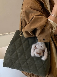Sac fourre-tout matelassé vert foncé avec chaîne dorée et breloque lapin sur mannequin