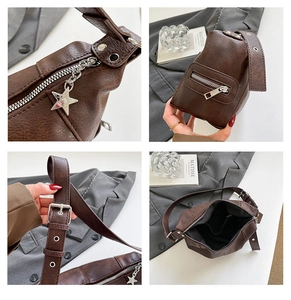 Detail of vintage brown pebble leather bag with star-shaped zipper and adjustable strap