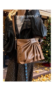 Sac cabas plissé marron avec détails métalliques lors d'un shooting de mode automnal