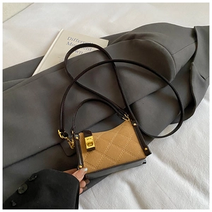 Close-up of a mini quilted crossbody bag with golden metal clasp and retro matte finish