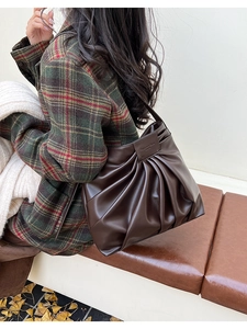 Détail montrant la texture plissée marron foncé et l'étiquette en cuir du sac cabas