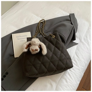 Detail van gewatteerde antraciet shopper met gouden ketting en konijntjeshanger