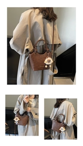 Detail of vintage brown leather bucket bag featuring a sheep charm and metal logo