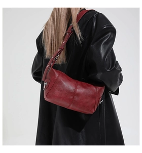 Detail of red vintage hobo bag showing soft leather texture and silver zipper accents