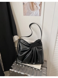Détail du sac cabas plissé en cuir noir montrant la texture souple et les boucles dorées