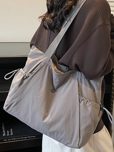 Large grey nylon tote bag with drawstring sides and wide shoulder strap for women