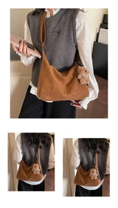 Detail of a brown suede hobo bag with a plush bear charm and adjustable wide shoulder strap
