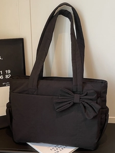 Chic black tote bag with large bow decoration and side pockets for casual use