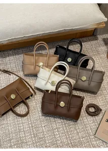 Detail view of colorful vintage tote bags with textured leather and metal buckle closures