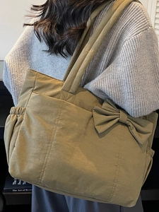 Olive green tote bag with large bow decoration and wide strap in casual canvas material