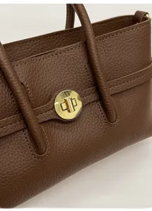 Detailed close-up of brown litchi pattern leather bag with golden cylindrical twist lock