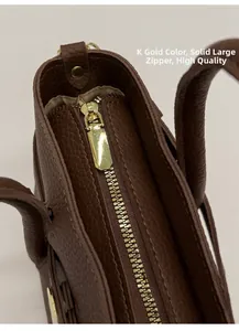 Close-up of textured dark brown leather bag featuring premium K-gold solid metal zipper