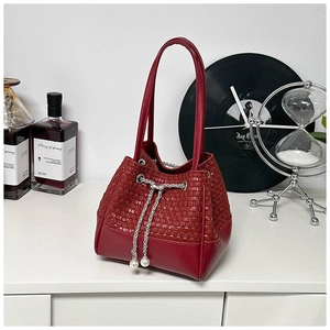 Detail of red woven bucket bag with silver chain drawstring and pearl charms