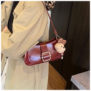 Détail du sac baguette en cuir PU bordeaux avec boucle en métal et breloque ours en peluche