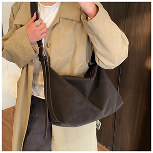 Detail showing the white contrast stitching on a dark brown textured hobo shoulder bag