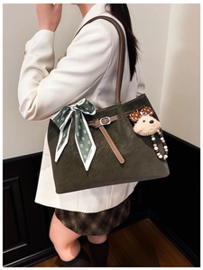 Vue latérale du sac fourre-tout vert foncé avec foulard fleuri et peluche sur mannequin