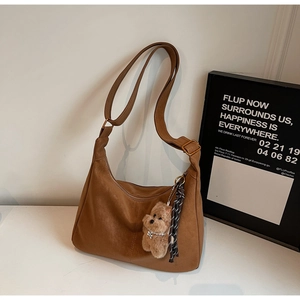 Detailed macro view of brown vintage textured tote bag with cute plush bear charm