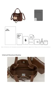 Detail view of brown litchi leather bucket bag with inner pouch and bear charm