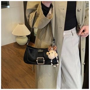 Détail du sac porté épaule noir brillant avec boucle argentée et charm ours peluche