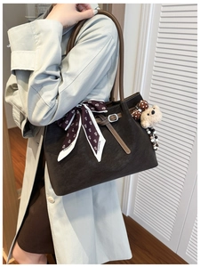 Détail du sac cabas en cuir mat marron foncé avec foulard fleuri et breloque en peluche