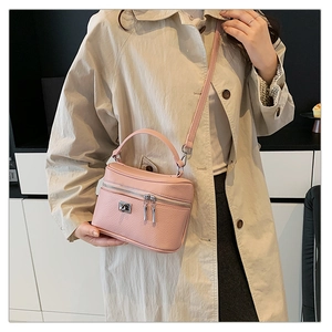 Dettaglio della borsa a scatola in pelle rosa con serratura in metallo indossata