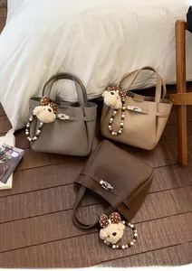 Three solid color bucket bags in pebble leather with metallic twist locks and charms
