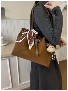 Détail du sac cabas marron avec foulard imprimé et pendentif en forme d'ours mignon