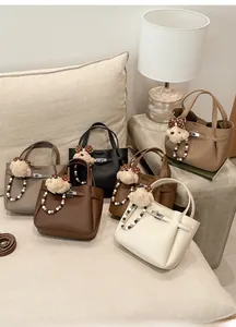 Detail view of stylish leather bucket bags in multiple colors with bear pendants