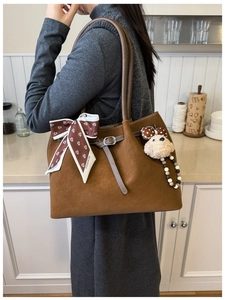 Détail du sac cabas vintage en daim marron avec foulard mode et breloque chiot