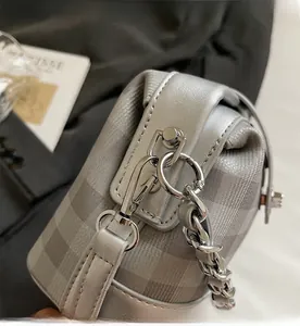 Detail of silver checkered bag featuring premium polished metal chain and twist lock