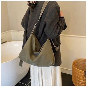 Detail of olive green slouchy hobo bag with wide shoulder strap and visible stitching