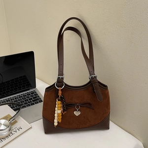 Detail of vintage leopard shoulder bag showing side wooden beads and heart-shaped pendant