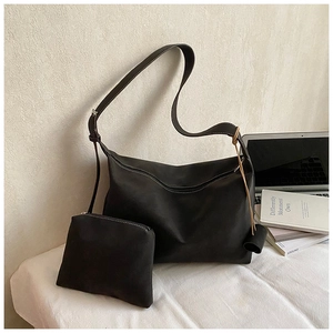 Detail of black pleated tote bag with white contrast stitching and matching small pouch