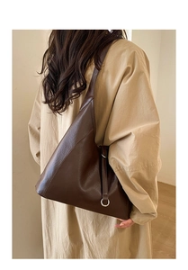 Detail view of large dark brown leather tote bag with silver ring and side strap details