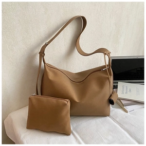 Detailed view of brown ruched tote bag and matching pouch with textured leather finish
