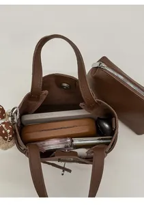 Internal storage detail of brown lychee grain bucket bag with matching small pouch