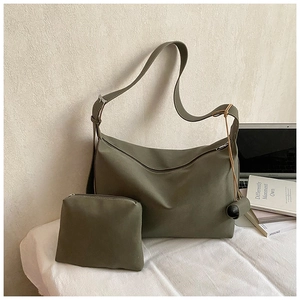 Olive green pleated tote bag and pouch set next to a laptop on a white surface