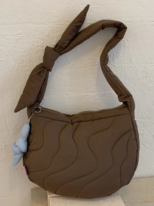 Brown quilted crossbody bag with a knotted shoulder strap and blue rabbit plush charm