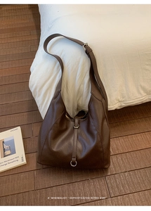 Detail of soft dark brown leather hobo bag showing the silver ring and strap texture