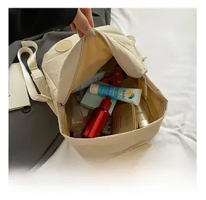 Détail de l'intérieur spacieux avec rangements d'un sac à dos de voyage beige en nylon léger